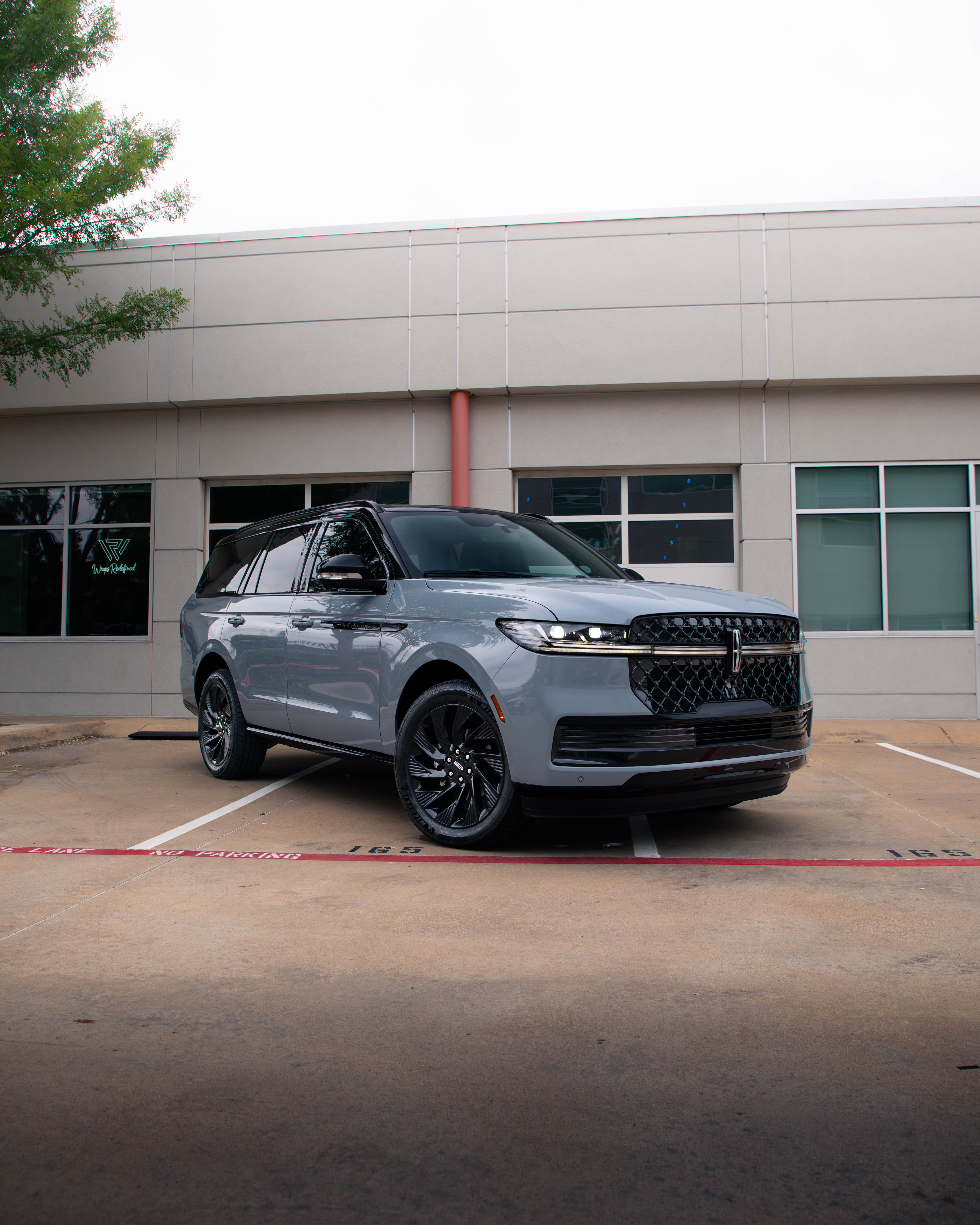 Grey Lincoln Navigator with black tuxedo roof and blackout trim