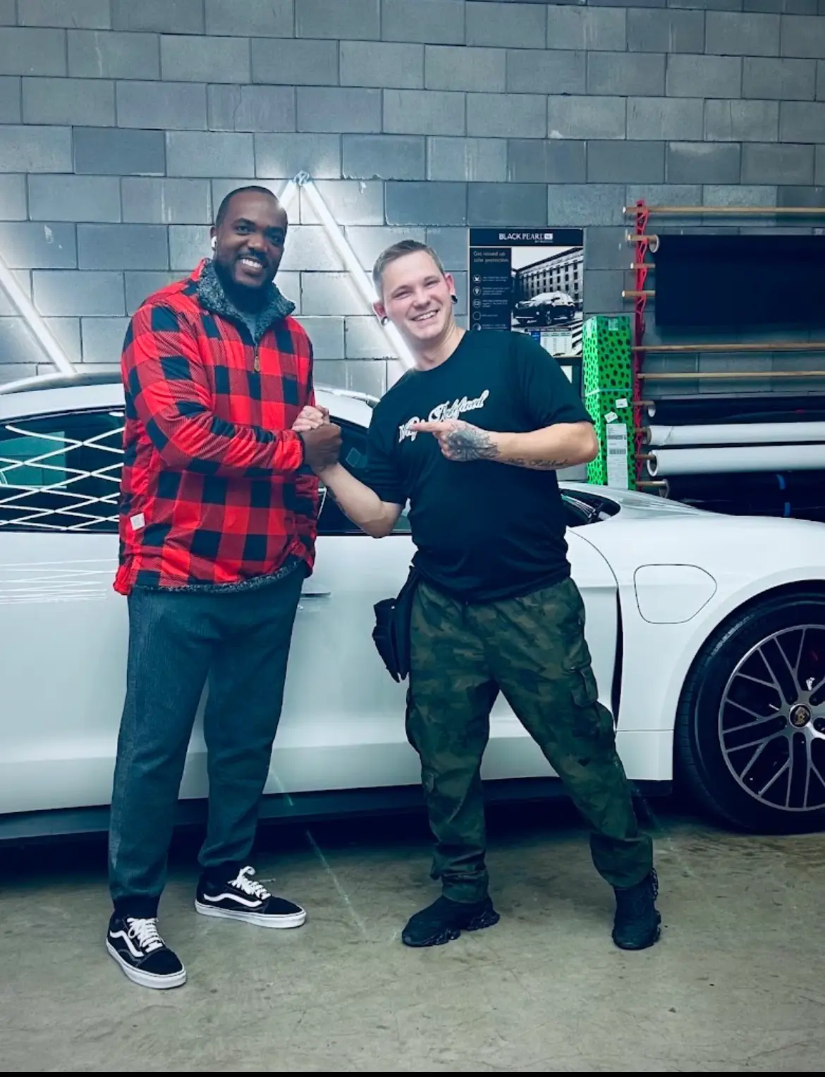 Allyn from Wraps Redefined shaking hands with a happy customer beside a freshly wrapped car